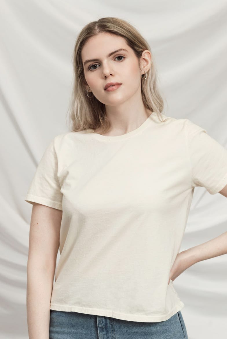 Model wearing women's off-white cotton crewneck tee.
